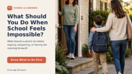 A concerned young child with a backpack receiving calm reassurance from a caregiver near a school entrance.