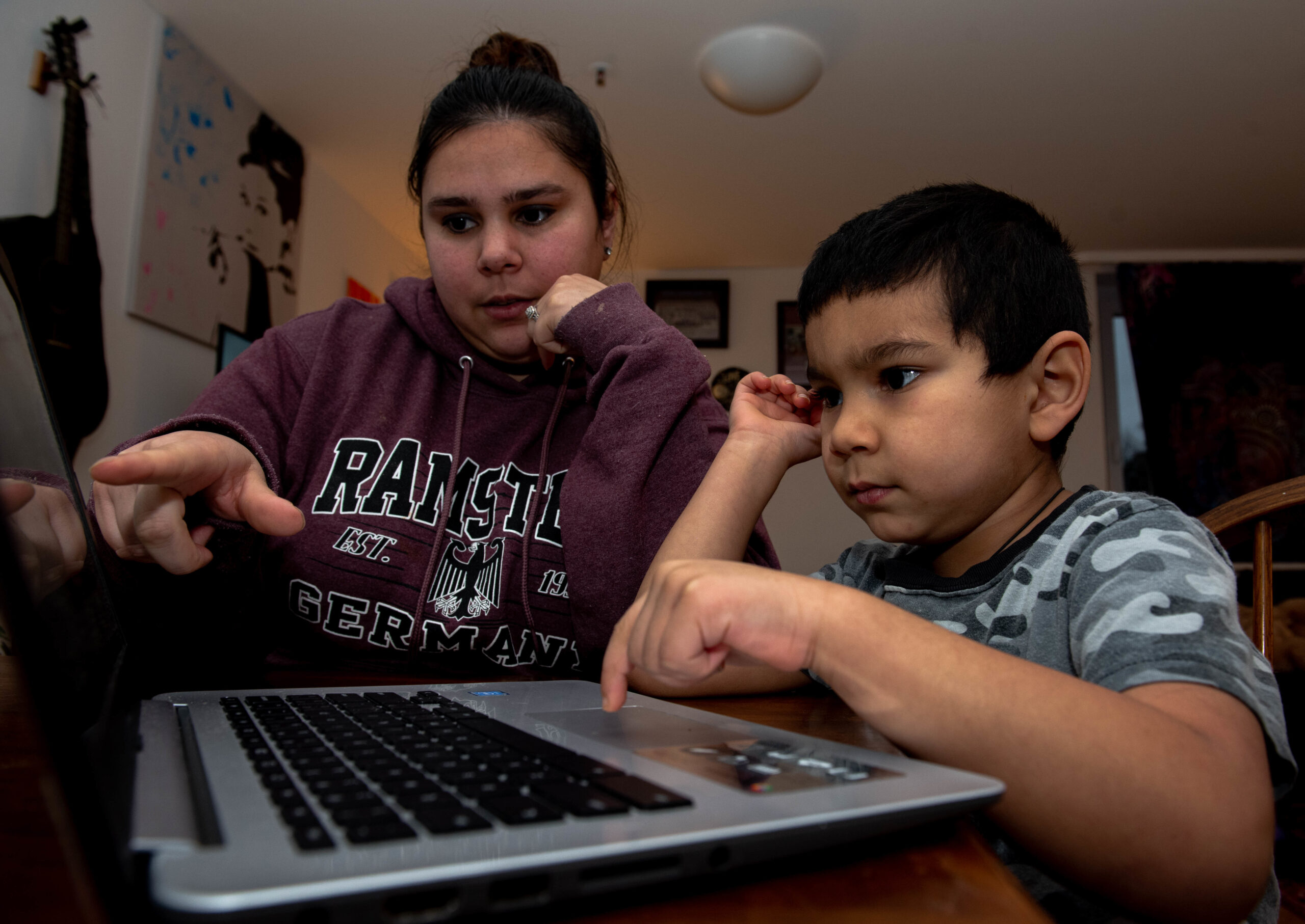 Parent and school-age child reviewing homework together on a laptop