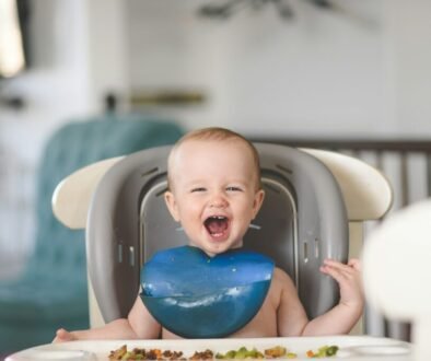 A baby lies calmly in a small bath, illustrating a gentle, supervised bath-time routine.