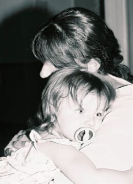 A caregiver holding a young child, used to illustrate a prepared babysitter handoff.