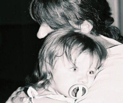 A caregiver holding a young child, used to illustrate a prepared babysitter handoff.