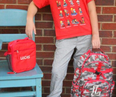 School-age child carrying a backpack outdoors.