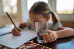 A child working on homework at a table, illustrating a calm practice approach to mistakes and schoolwork.