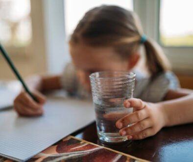 A child working on homework at a table, illustrating a calm practice approach to mistakes and schoolwork.