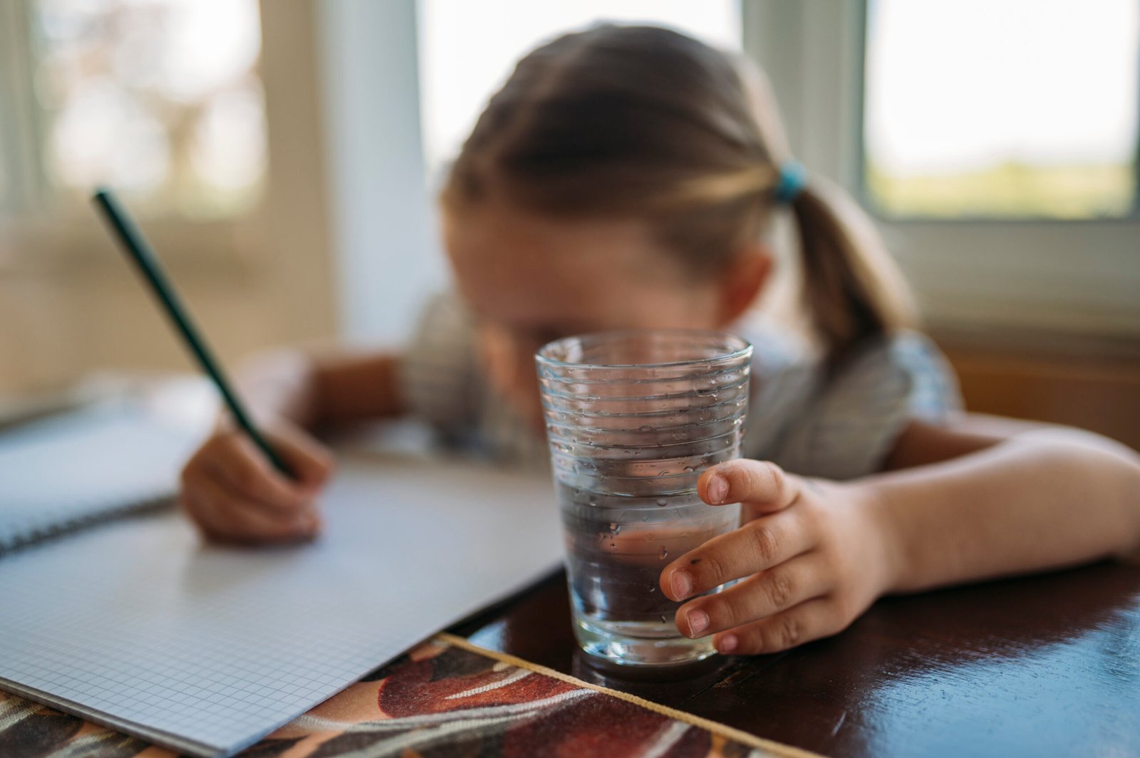A child working on homework at a table, illustrating a calm practice approach to mistakes and schoolwork.