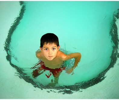 A child in a swimming pool, used as an editorial illustration for a guide about ear pain after swimming.