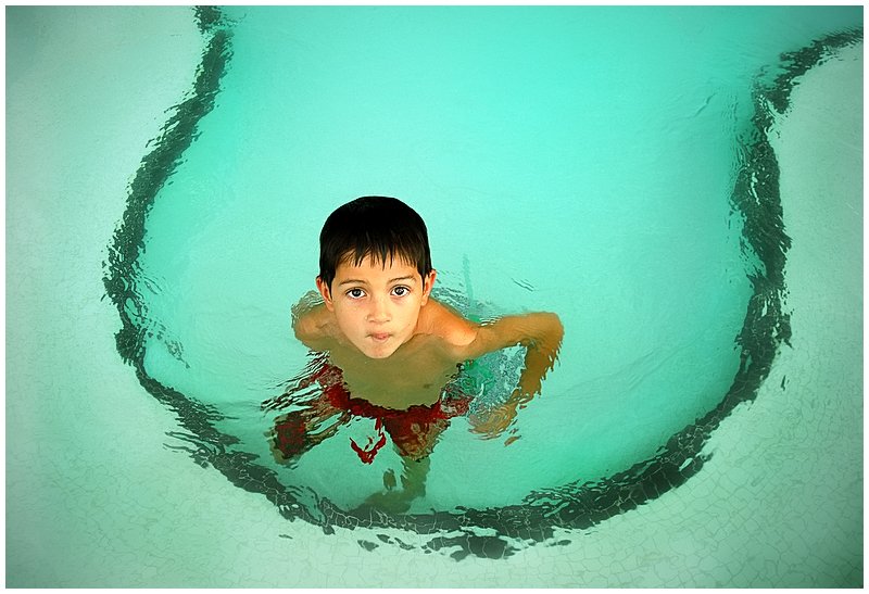 A child in a swimming pool, used as an editorial illustration for a guide about ear pain after swimming.