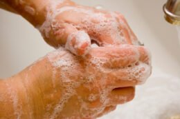 Hands being washed with soap at a sink, illustrating the hygiene step in a kindergarten bathroom-independence plan.