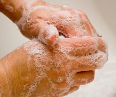 Hands being washed with soap at a sink, illustrating the hygiene step in a kindergarten bathroom-independence plan.