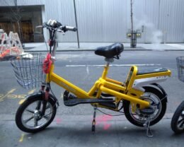 Yellow electric bicycle parked on a city street.