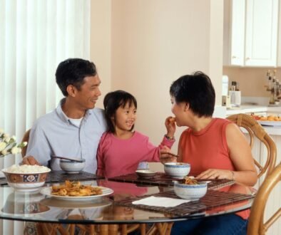 A family sharing a meal at a table, used as an editorial illustration for responsive baby mealtimes.