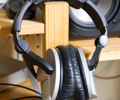 Over-ear headphones shown as an editorial illustration for a parent guide about volume-limiting headphones and a child’s school tablet.