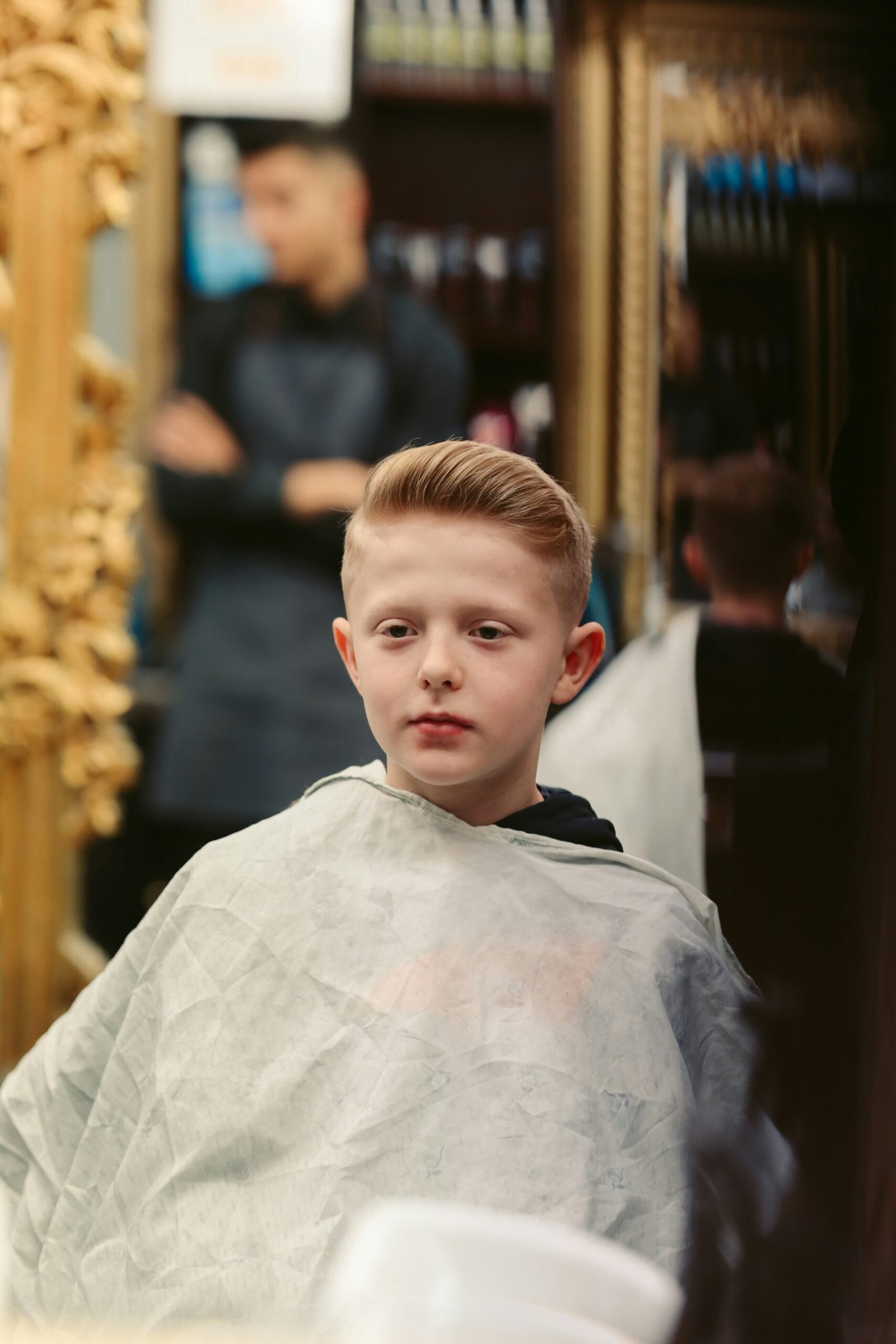 A young child receiving a haircut at a barber shop.