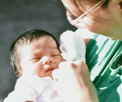 A parent holds a sleeping newborn; editorial image for a guide to sharing overnight newborn care.