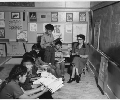 A teacher works with children in a classroom; a public-domain National Archives image used as an editorial illustration for classroom supports.