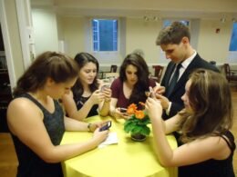 A small group of young people using smartphones, used as an editorial illustration for a parent guide to Discord age verification.