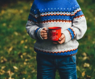 A young child holding a red cup outdoors.