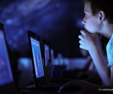 A child using a computer as a reminder that a predictable video call can support connection when a parent travels for work.