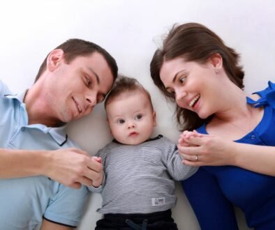 Two parents holding and looking at their baby at home.