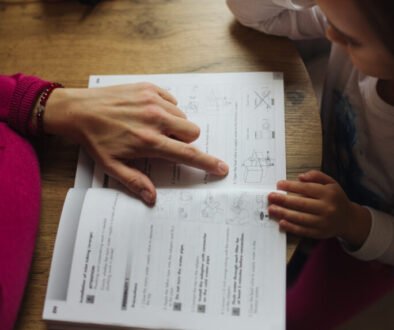 A parent and young child working together at a table at home.