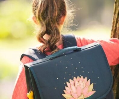A school-age child wearing a backpack, used as an editorial illustration for a family guide about ringworm, school, and PE.