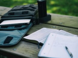 A student writes in a notebook beside open books, illustrating a focused reading and schoolwork routine.