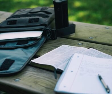 A student writes notes beside an open book and study materials, illustrating a planned homework session.